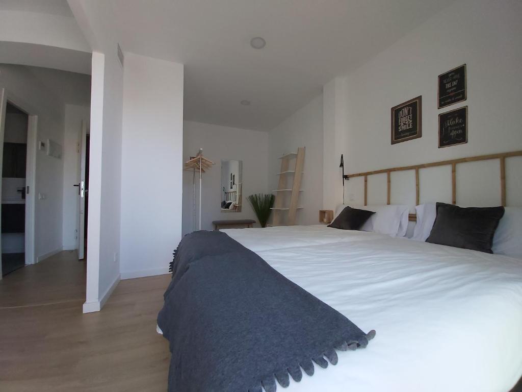A bed or beds in a room at Acero y Piedra Apartamentos con jardín privado