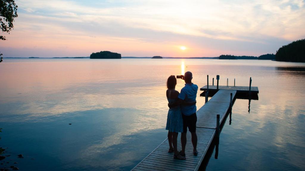 a woman standing on a pier looking at the water at Petäys Resort in Tyrväntö