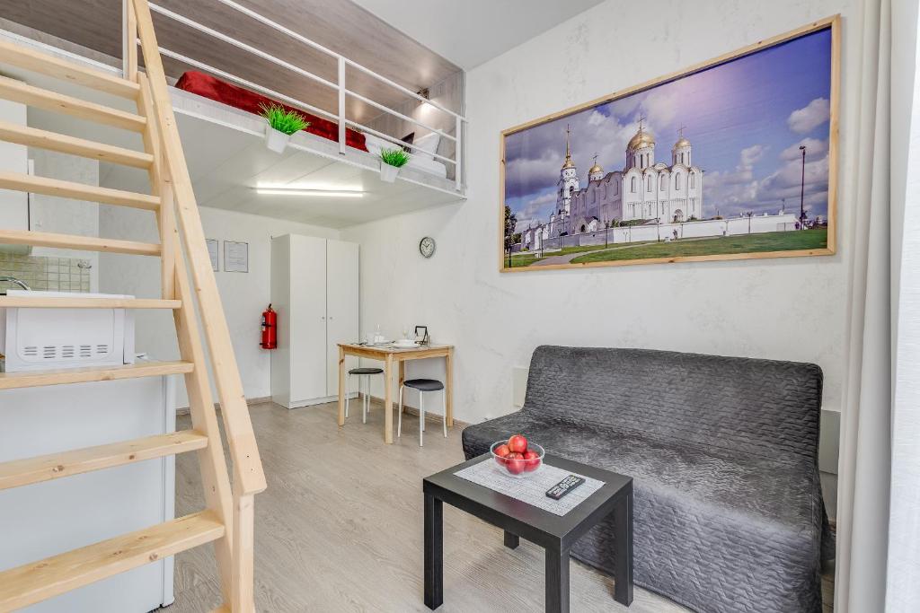 uma sala de estar com um sofá e uma cama alta em Sokroma Vladimirskaya Rus em Vladimir