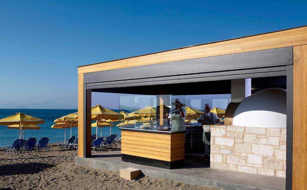 a restaurant on the beach with a view of the ocean at Mitsis Norida in Kardamaina