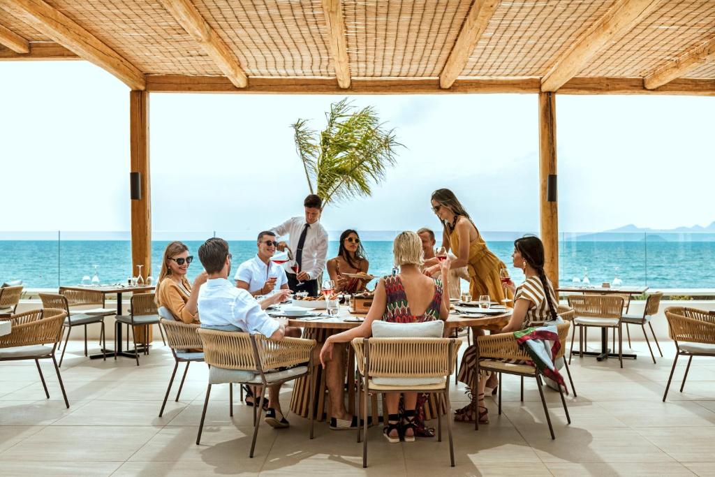a group of people eating at a restaurant on the beach at Mitsis Norida in Kardamaina