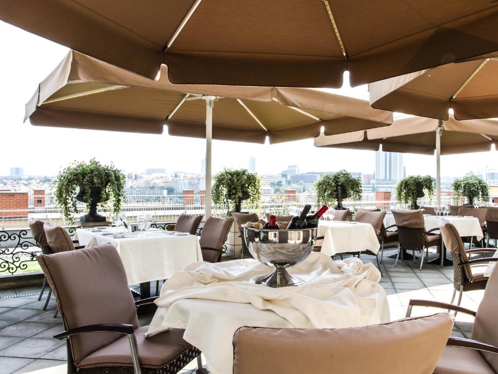 a restaurant with white tables and chairs and umbrellas at Le Palais Art Hotel Prague in Prague