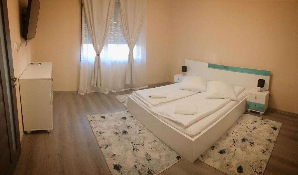 una camera con un letto bianco e una finestra di Milan house a Arad