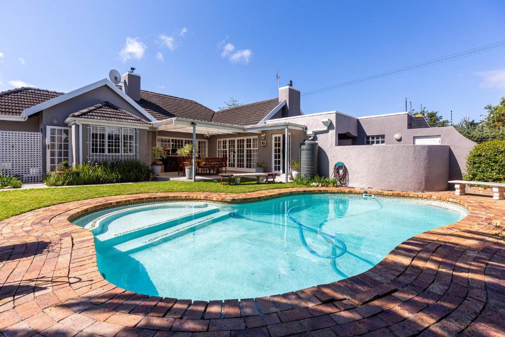 a swimming pool in front of a house at brookdale house in Cape Town
