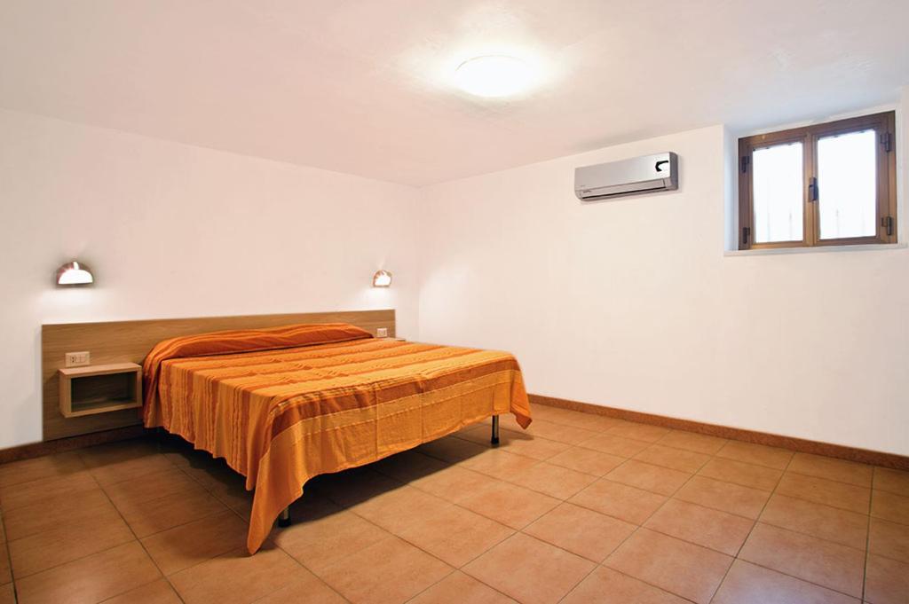 a bedroom with a bed with an orange blanket at Felicity Vieste in Vieste