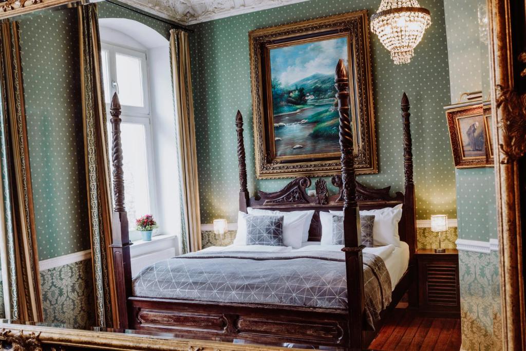 una camera con letto a baldacchino e grande specchio di Honigmond Boutique Hotel a Berlino