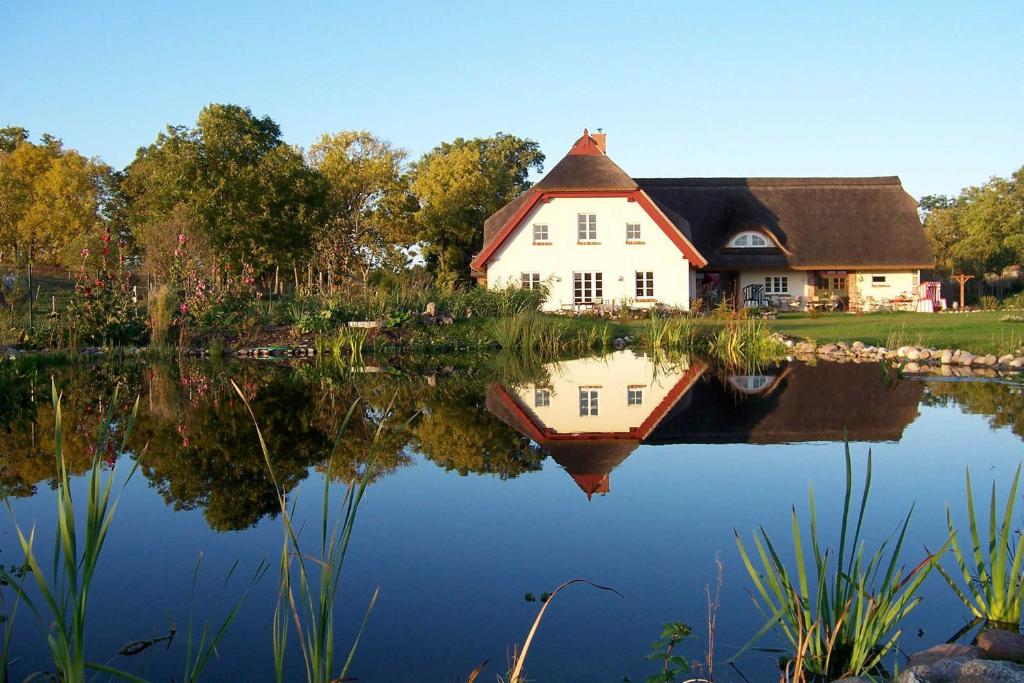 une maison avec sa réflexion dans l'eau dans l'établissement Natourlust Preetz - Die große Grüne, à Burtevitz