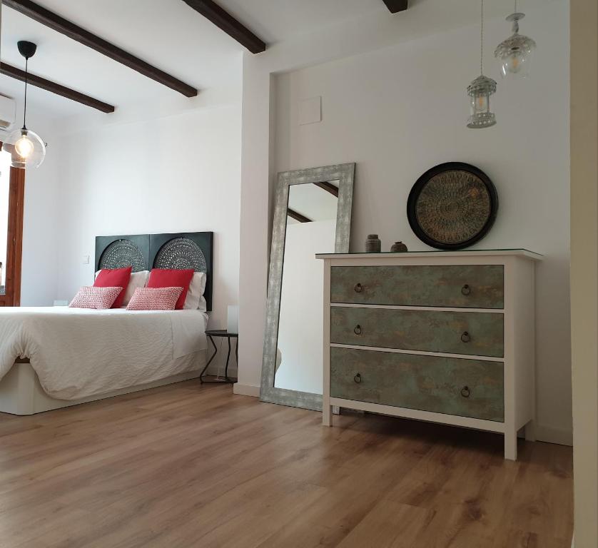 a bedroom with a bed and a dresser with a mirror at Apartamento Morisco in Toledo