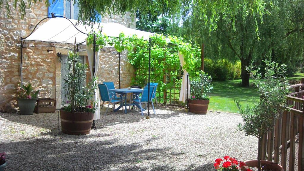 a patio with a table and chairs in a garden at The Studio in Hautefort