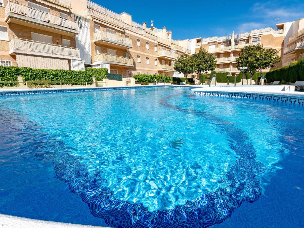 a large blue swimming pool in front of a building at Apartment Aires de mar by Interhome in Cunit