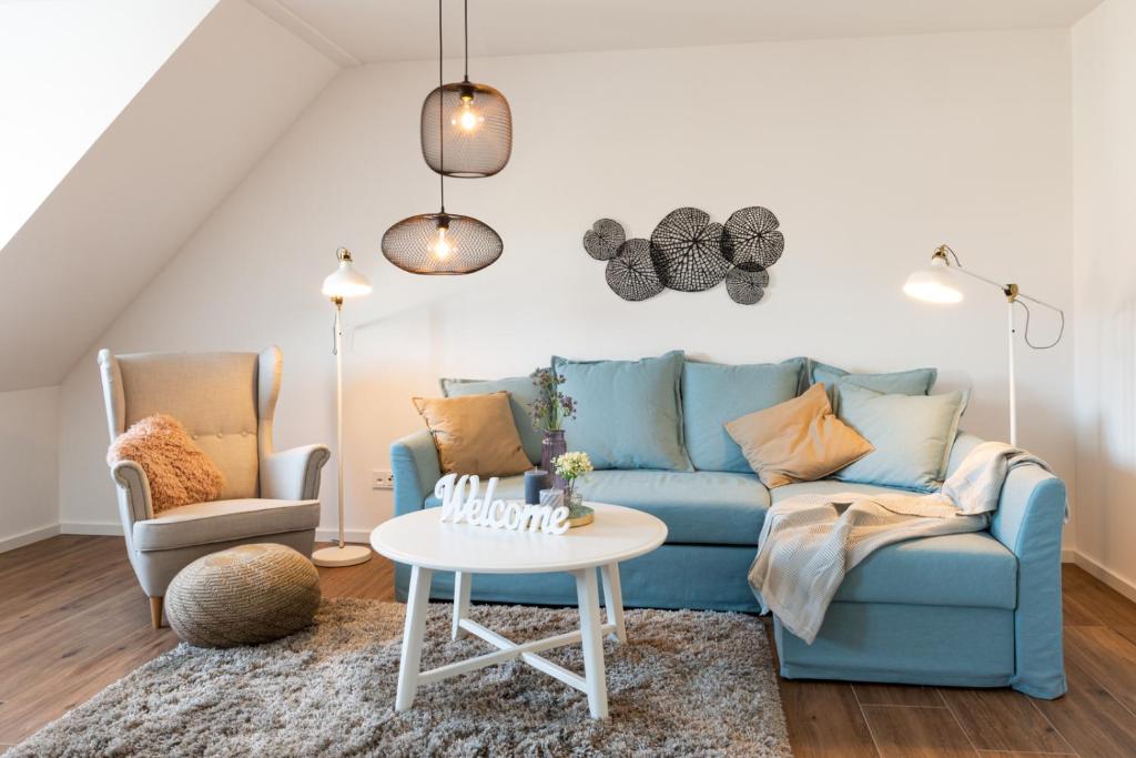 sala de estar con sofá azul y 2 sillas en NEU-Luxus Apartment-Zentral 350m Altstadt-2Zi-65qm, en Augsburg