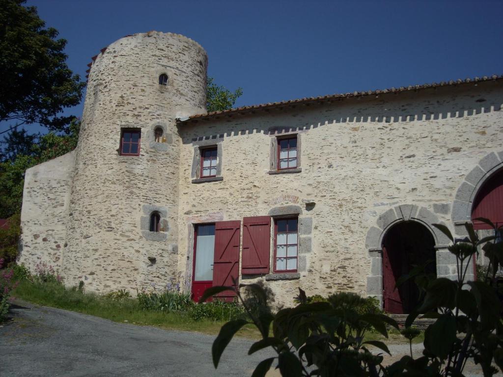 un ancien bâtiment en pierre avec une tour dans l'établissement La Tour des Laudes, à Breuil-Barret