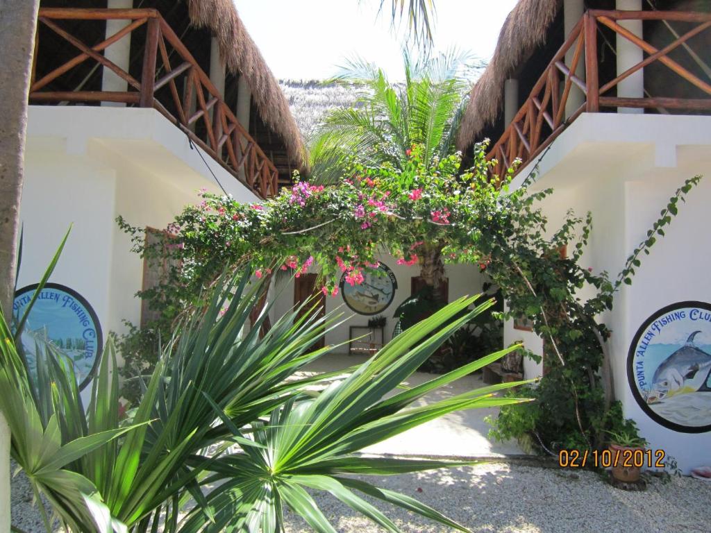 a courtyard of a resort with pink flowers and plants at Casa Pascale in Punta Allen