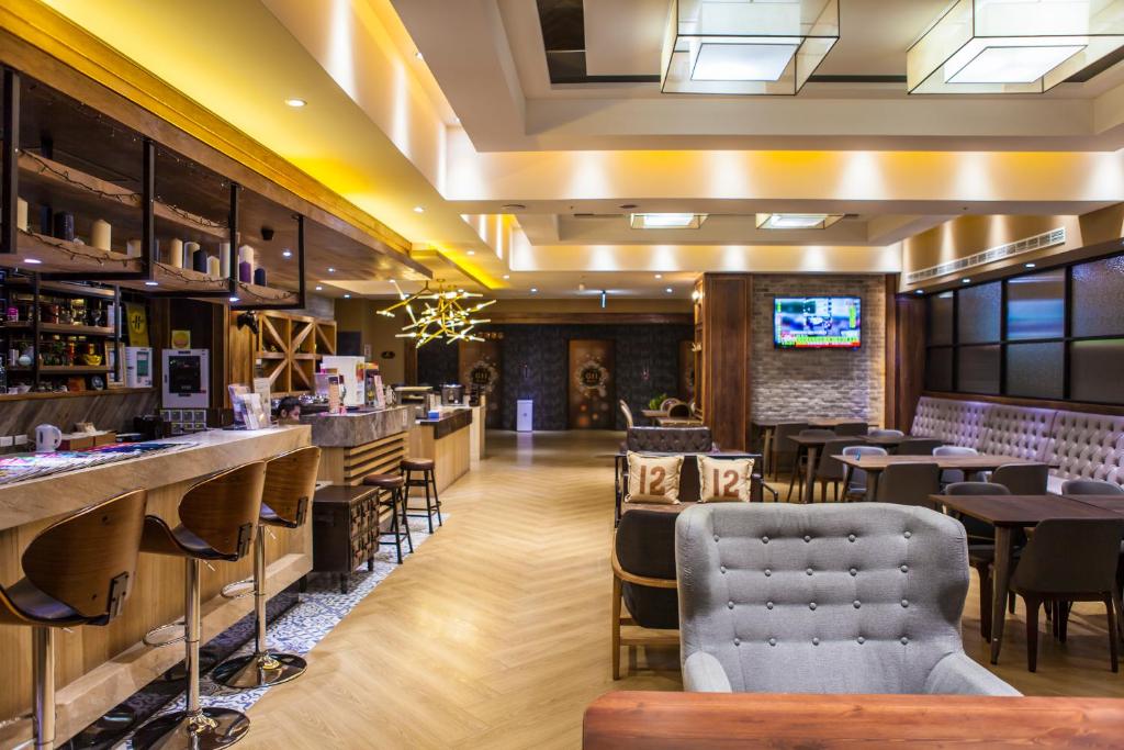 a restaurant with tables and chairs and a bar at G11 Hotel in Taichung