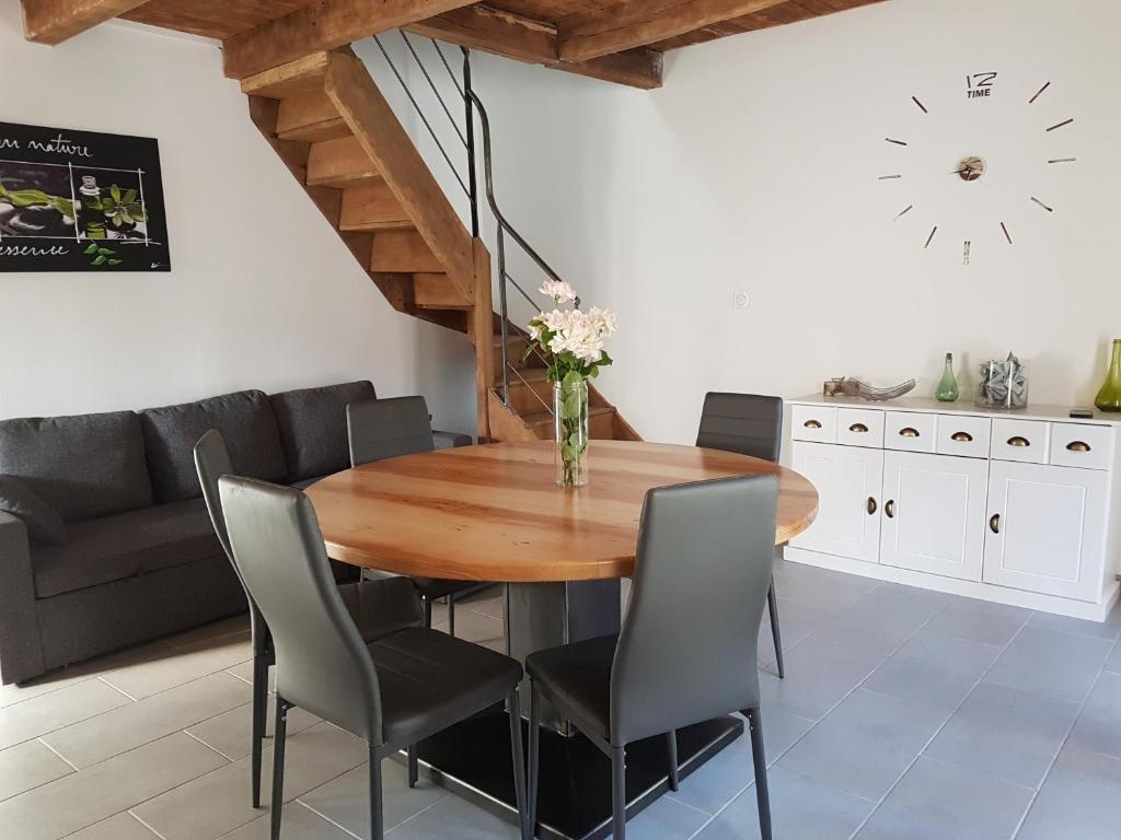 uma sala de jantar com uma mesa de madeira e cadeiras em LA MAISON DE JADE em Soursac