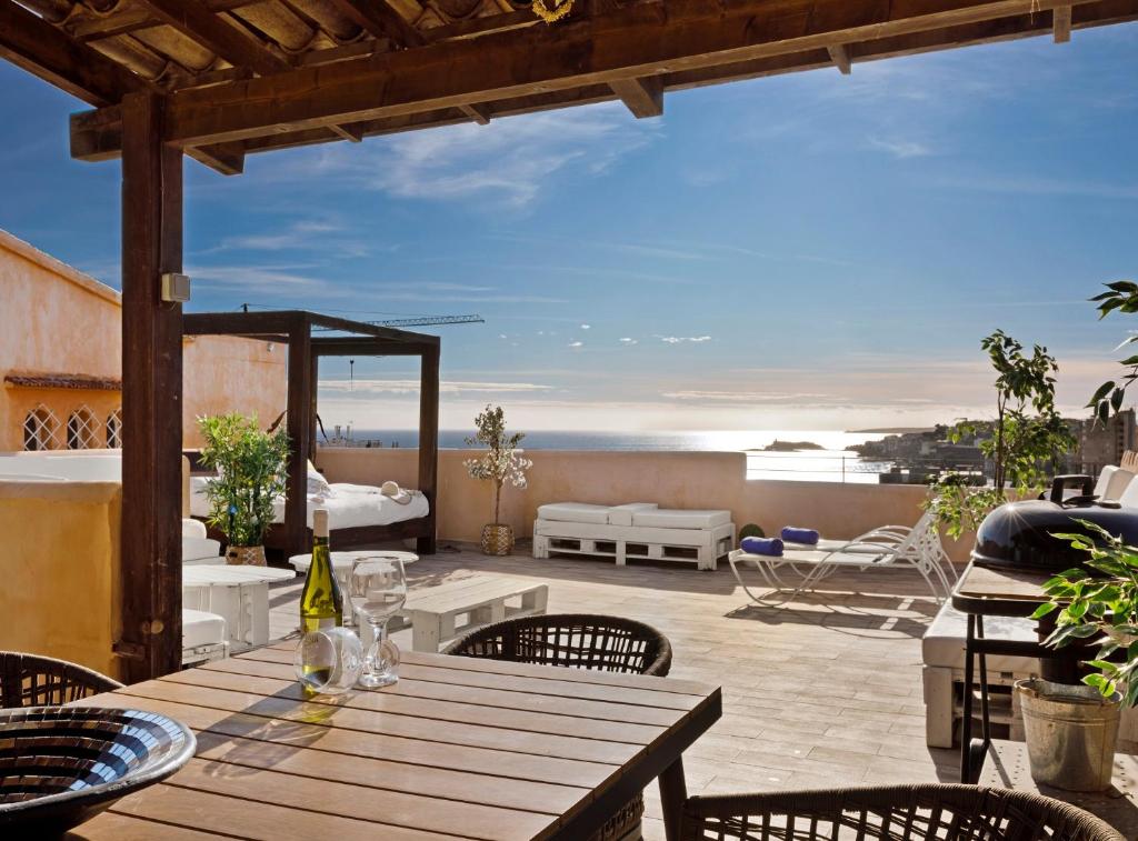 a wooden table on a patio with a view of the ocean at Villa Can Moya in Palma de Mallorca