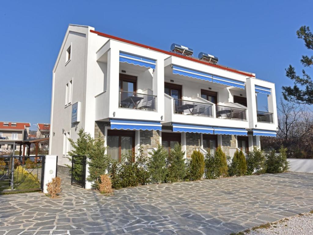 ニキティにあるAzur Apartments - Nikiti Halkidikiの青色のアクセントが施された白い建物