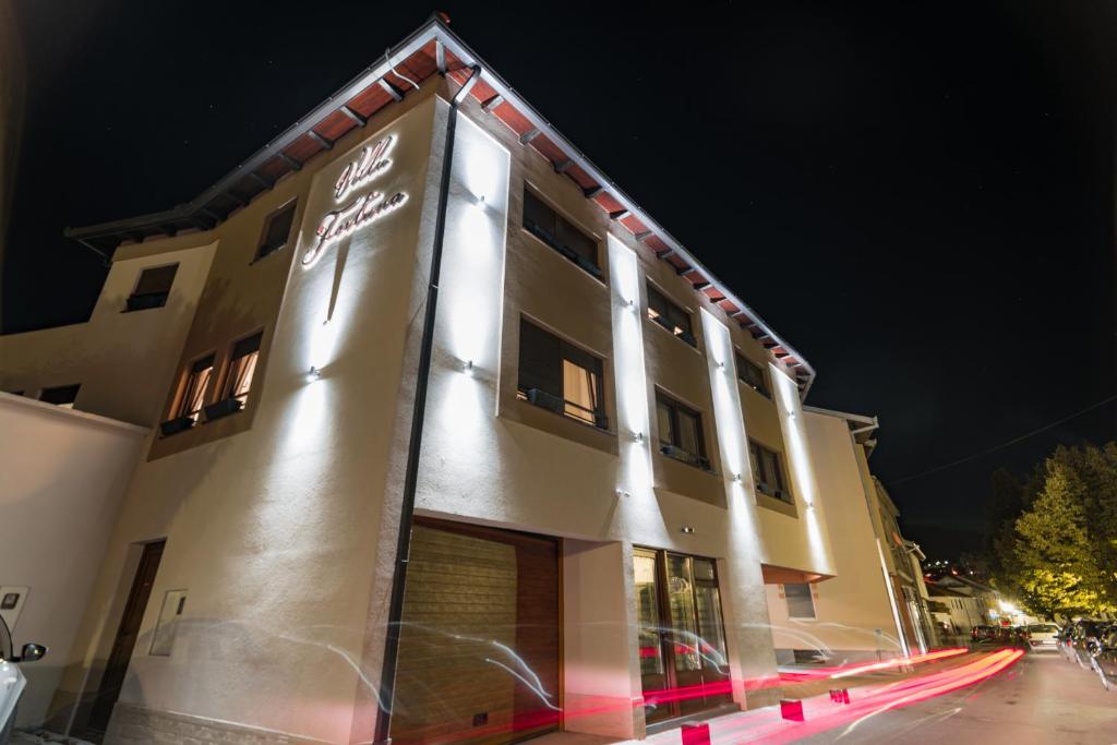 un edificio con luci sul lato di esso di notte di Villa Fortuna a Mostar