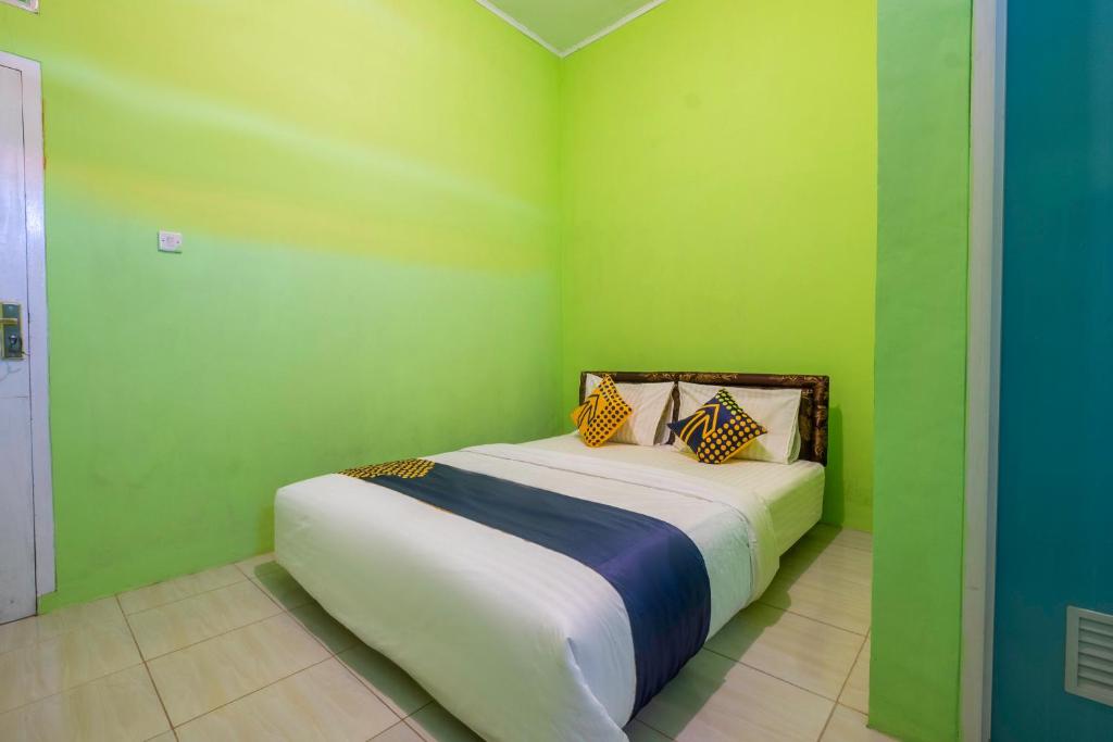 a bedroom with green walls and a bed in it at OYO 2859 Fatan Costel Syariah in Cianjur