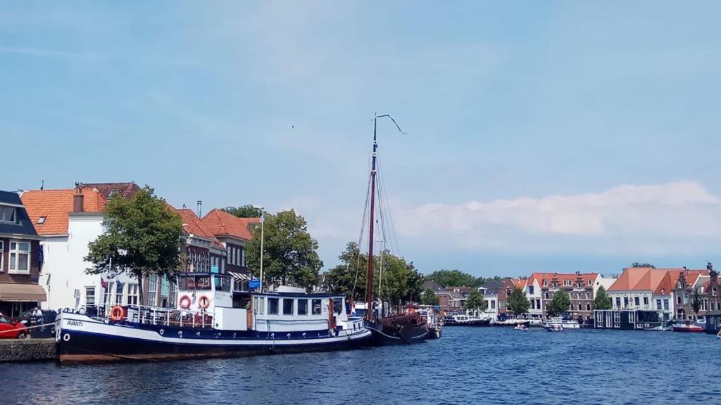 un barco está atracado en el agua junto a las casas en Amice en Haarlem