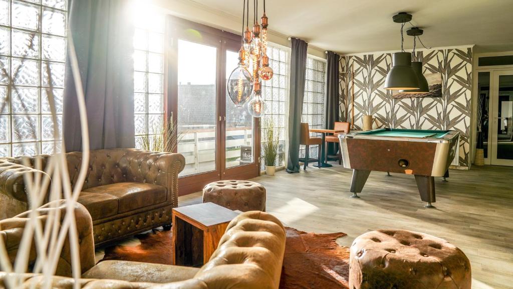 ein Wohnzimmer mit einem Sofa und einem Billardtisch in der Unterkunft Hotel dat Norden in Horumersiel