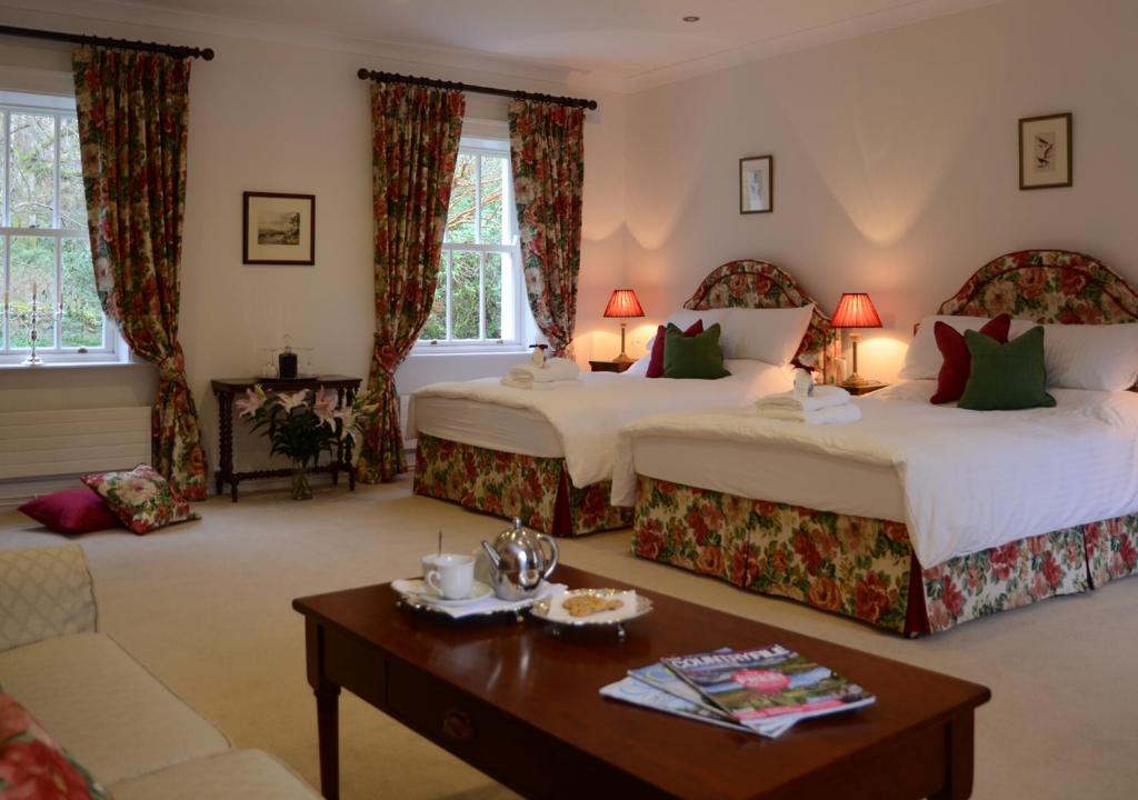 a hotel room with two beds and a table at Delphi Lodge in Leenaun