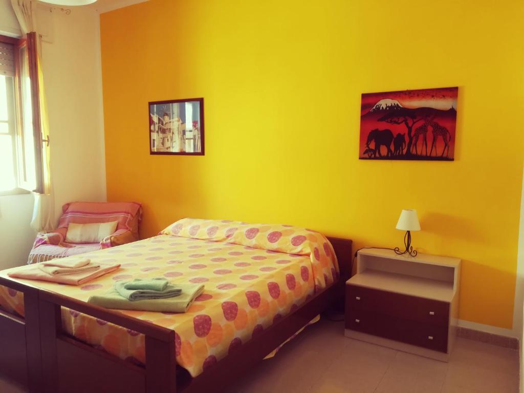 アルゲーロにあるB&B Fraluciaの黄色のベッドルーム(ベッド1台、椅子付)