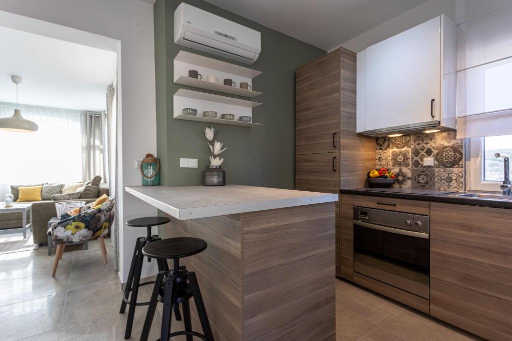 a kitchen with a counter and two bar stools at Pansion Tina in Šilo