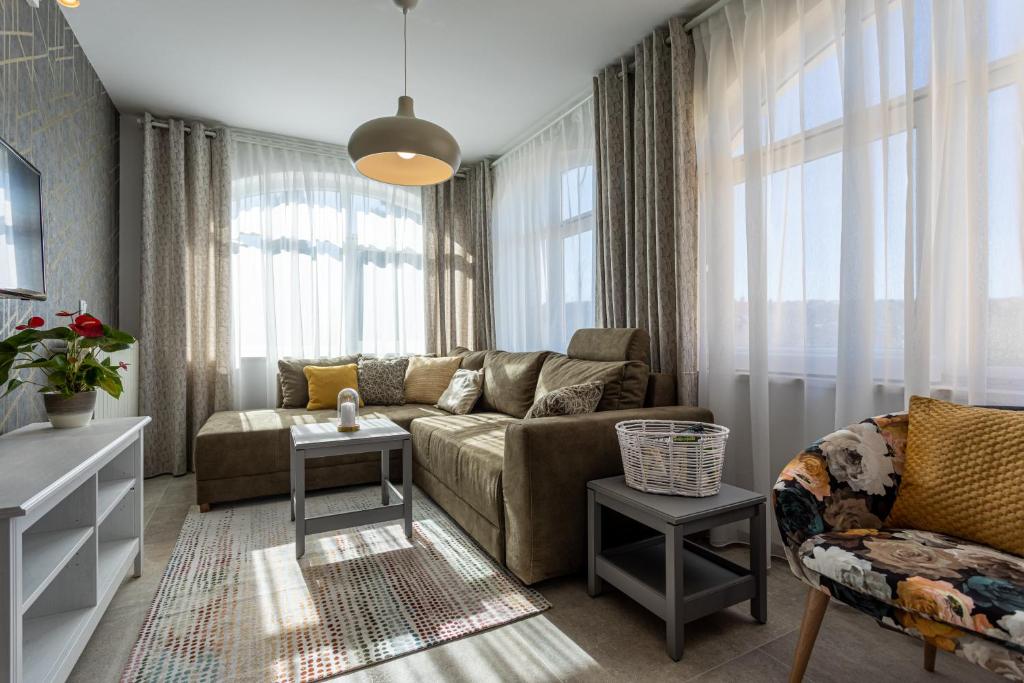 a living room with a couch and some windows at Pansion Tina in Šilo