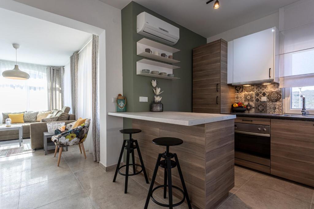 a kitchen with a counter and two bar stools at Pansion Tina in Šilo