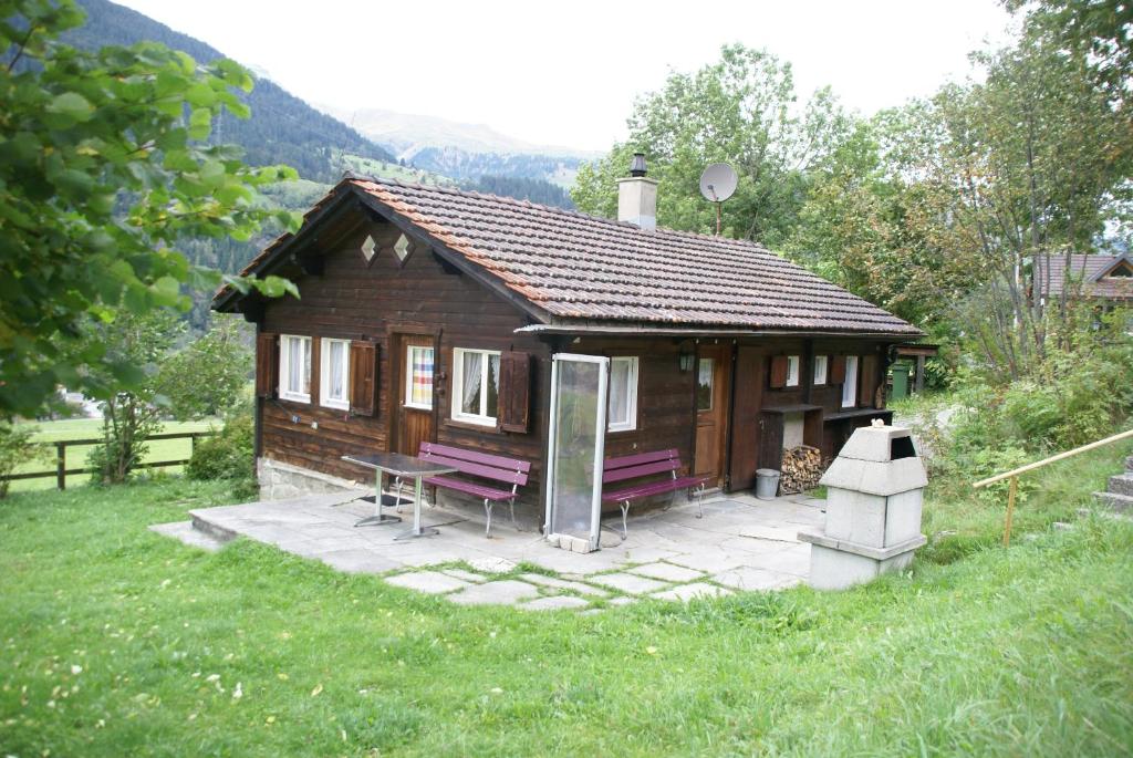 a small wooden cabin with a bench and a table at La Crappa in Andeer