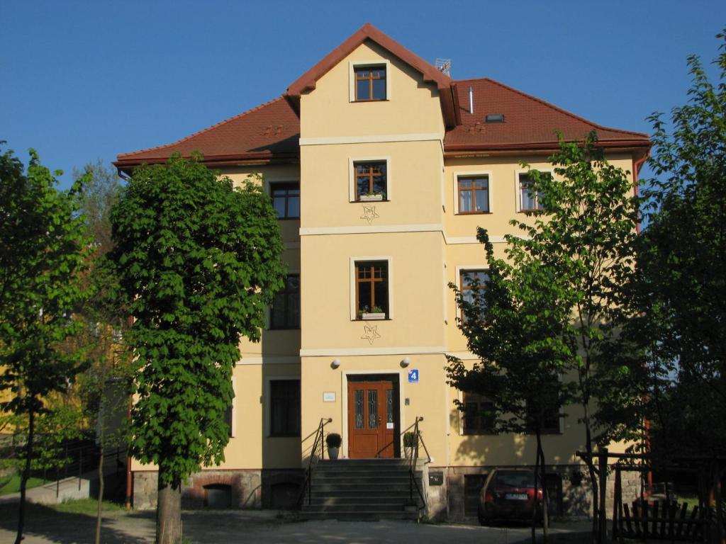 ein gelbes Haus mit rotem Dach in der Unterkunft Willa Pod Gwiazdami & SPA in Kudowa-Zdrój