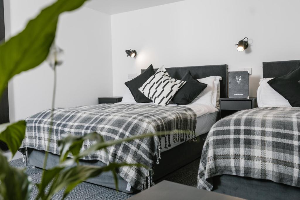 a bedroom with two beds with black and white pillows at Siberia Bar & Hotel in Aberdeen