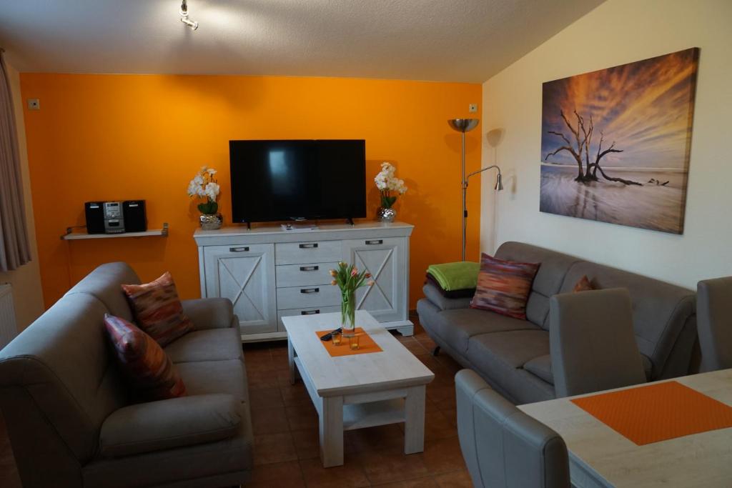een woonkamer met banken en een flatscreen-tv bij Ostetal in Hemmoor
