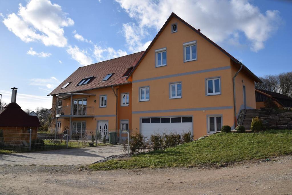 a large orange house with a white garage at Pferdefreunde Loberhof in Weihenzell