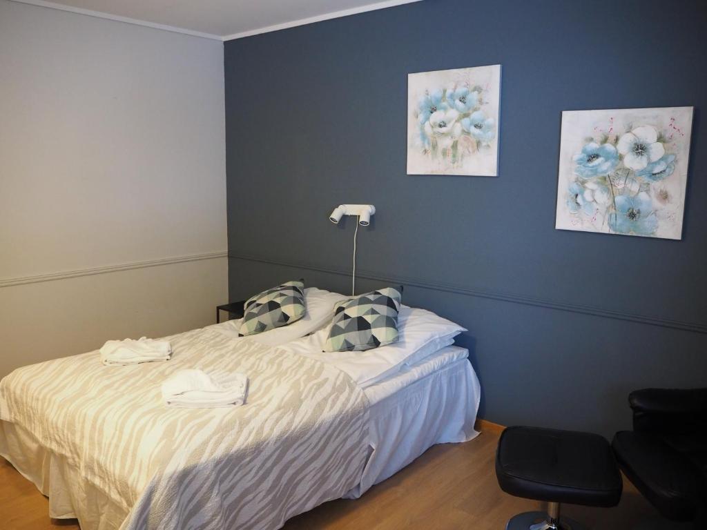 1 dormitorio con cama y pared azul en Stor-Elvdal Hotell en Koppang