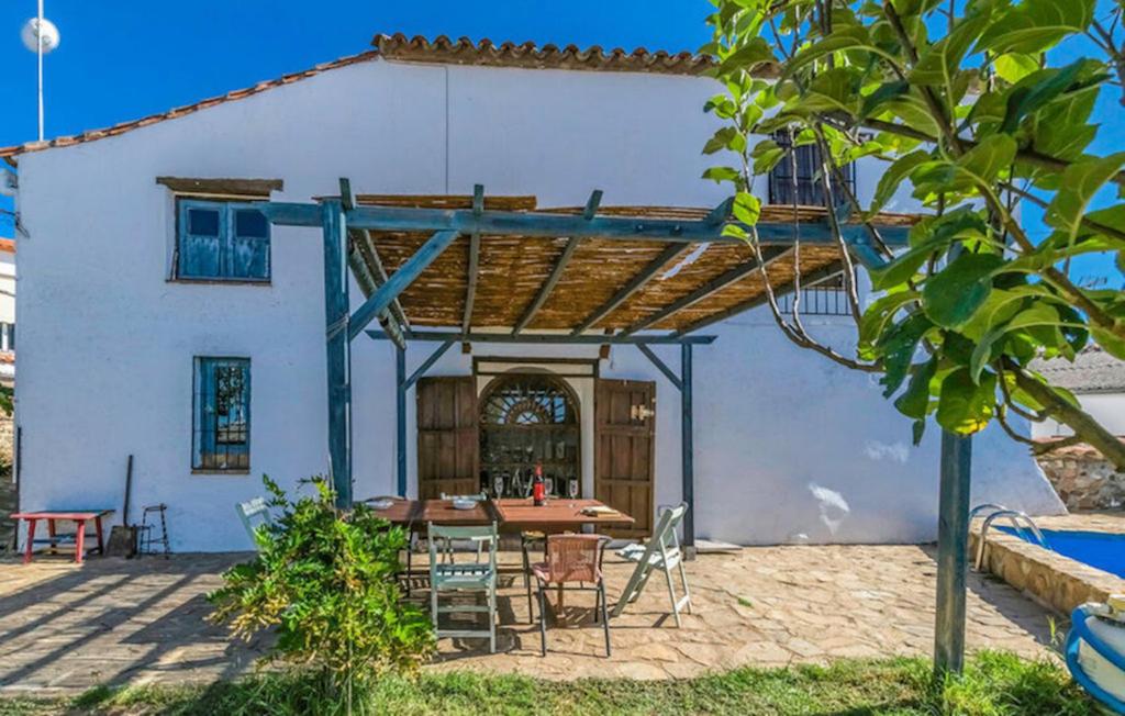 un patio con mesa y sillas frente a una casa en Casa Rural Ermita Azul, en Ojuelos Altos