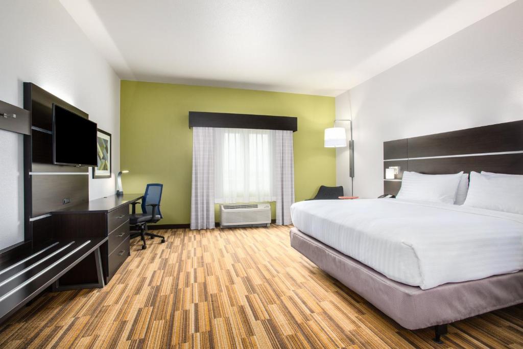 a hotel room with a bed and a flat screen tv at Holiday Inn Express & Suites - Rapid City - Rushmore South by IHG in Rapid City