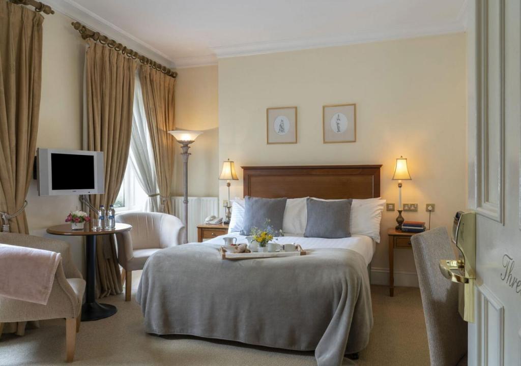 a hotel room with a bed and a chair and a television at Headfort Arms Hotel in Kells