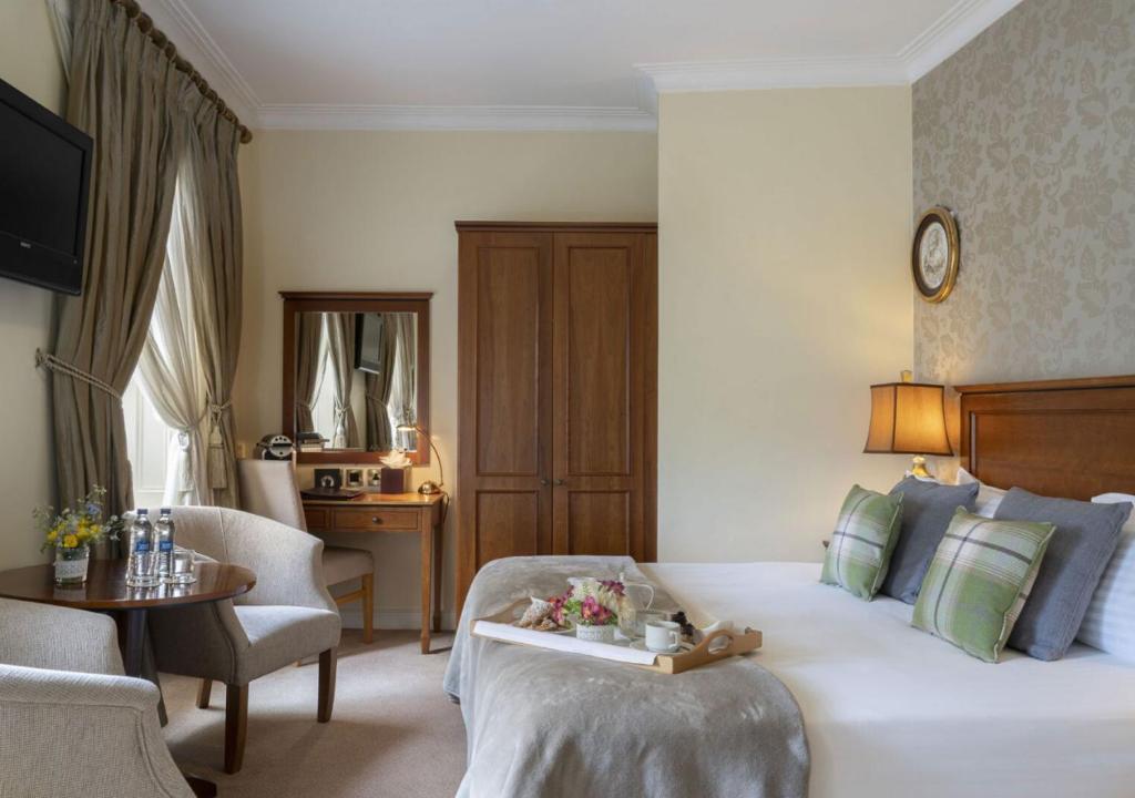 a hotel room with a bed and a chair and a table at Headfort Arms Hotel in Kells