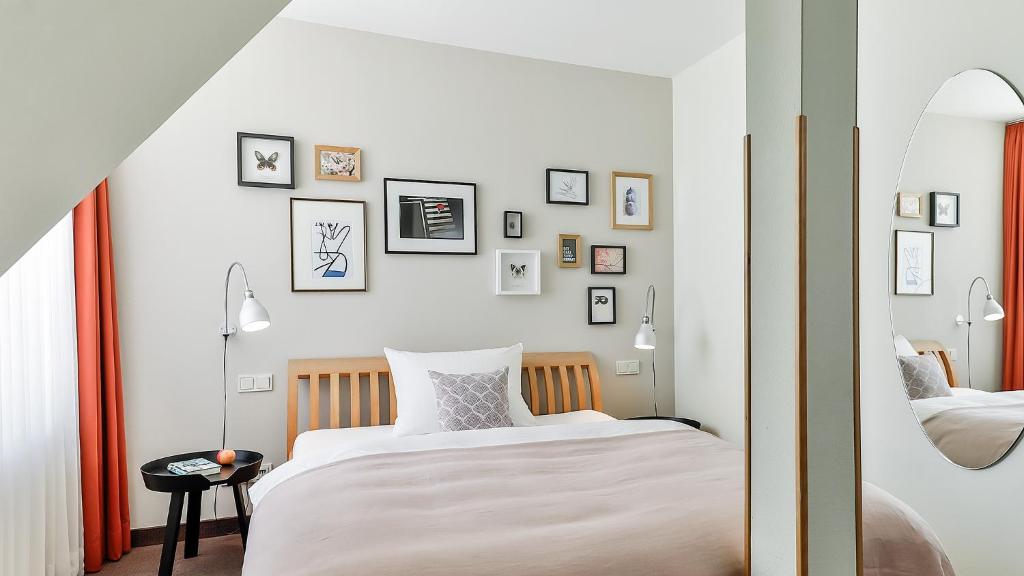 フランクフルト・アム・マインにあるBIO-Hotel Villa Orangeのベッドが2つあり、壁に絵が飾られている寝室