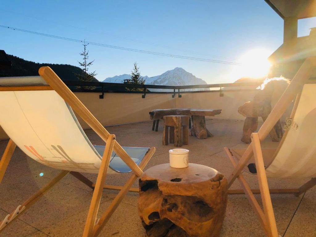 un paio di sedie e un tavolo su un patio di Appartement cocooning - Grande terrasse - bain nordique-Sauna - DOMAINE DU PATRE a Vaujany