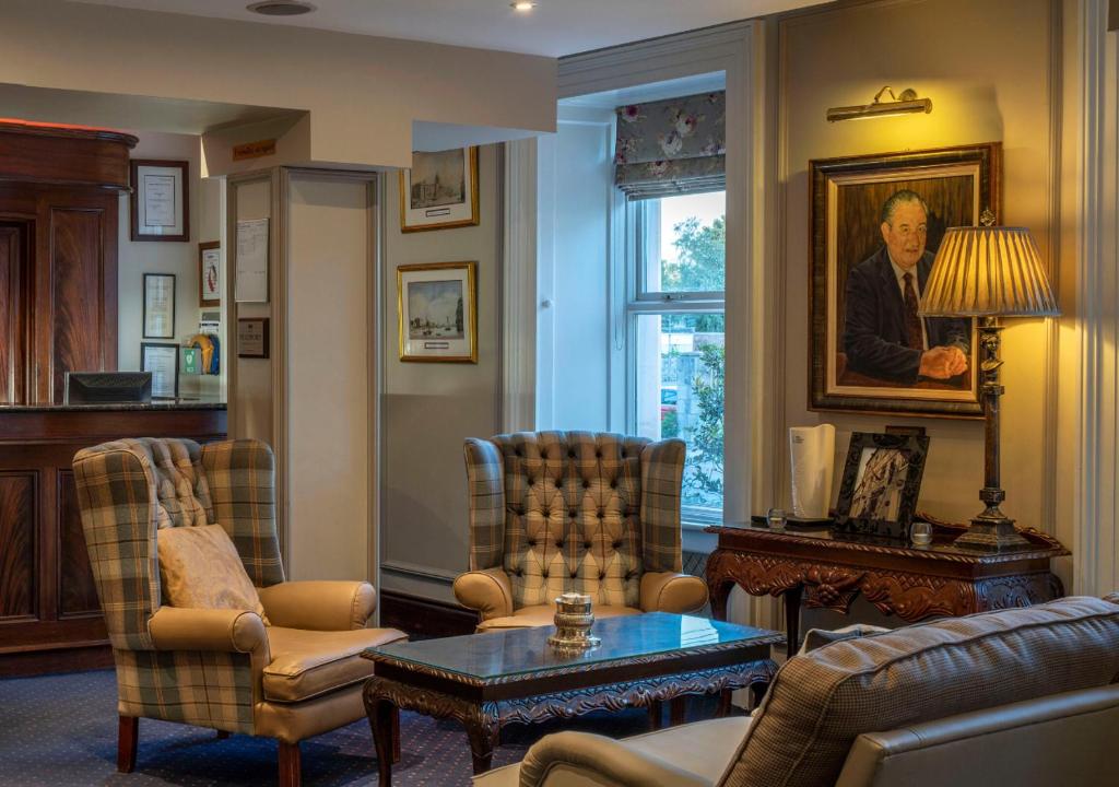 a living room with chairs and a painting of a man at Headfort Arms Hotel in Kells