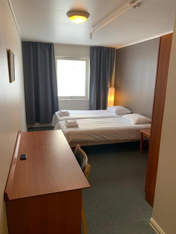 a hotel room with two beds and a table at Narvik Budget Rooms in Narvik