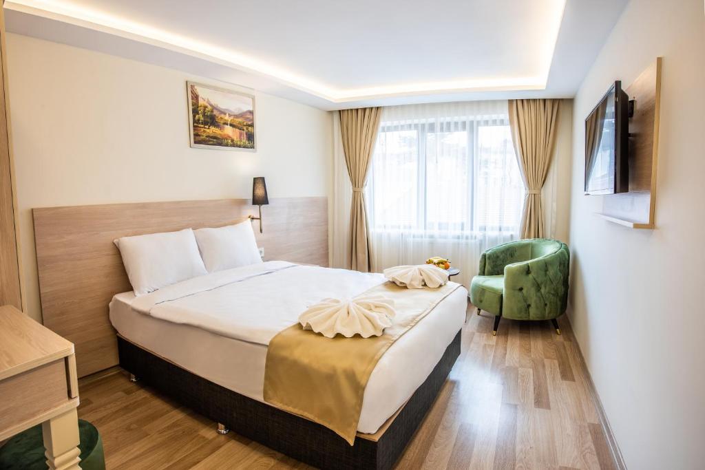 Habitación de hotel con cama y silla verde en Royal Bosphorus Hotel & SPA Hamam en Estambul