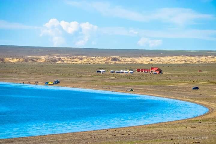 une grande piscine d'eau au milieu d'un champ dans l'établissement Khyargas Khuh Bukh, à Tsalgar