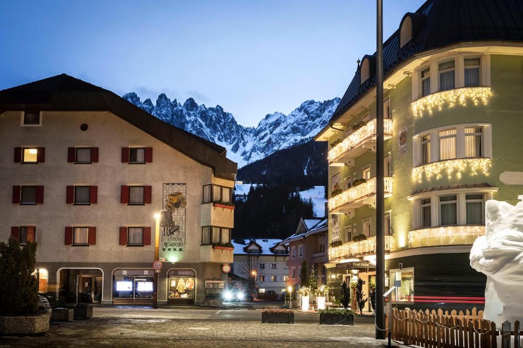 una calle en una ciudad con edificios y montañas en Post Residence, en San Candido