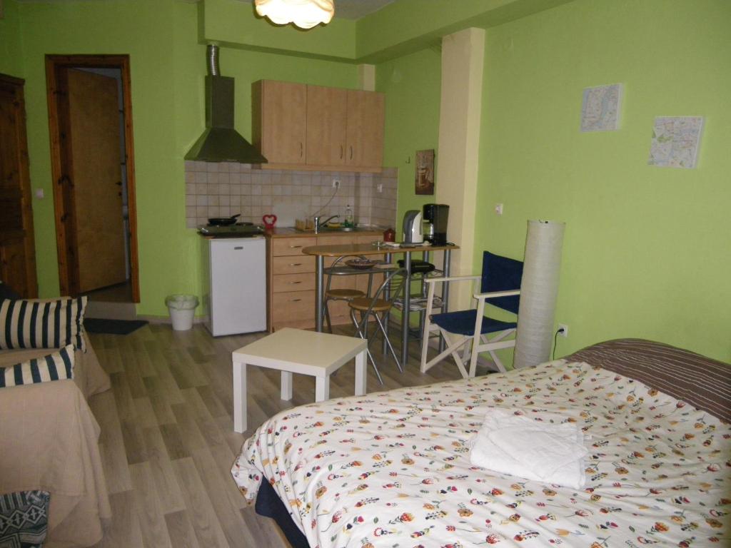 テッサロニキにあるHomy cozy studio towards the centreのベッドルーム1室(ベッド1台付)、緑の壁のキッチン