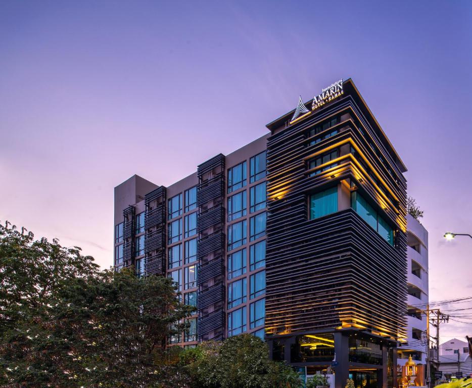 a tall building with a sign on top of it at Amarin Hotel Rama 8 in Bangkok