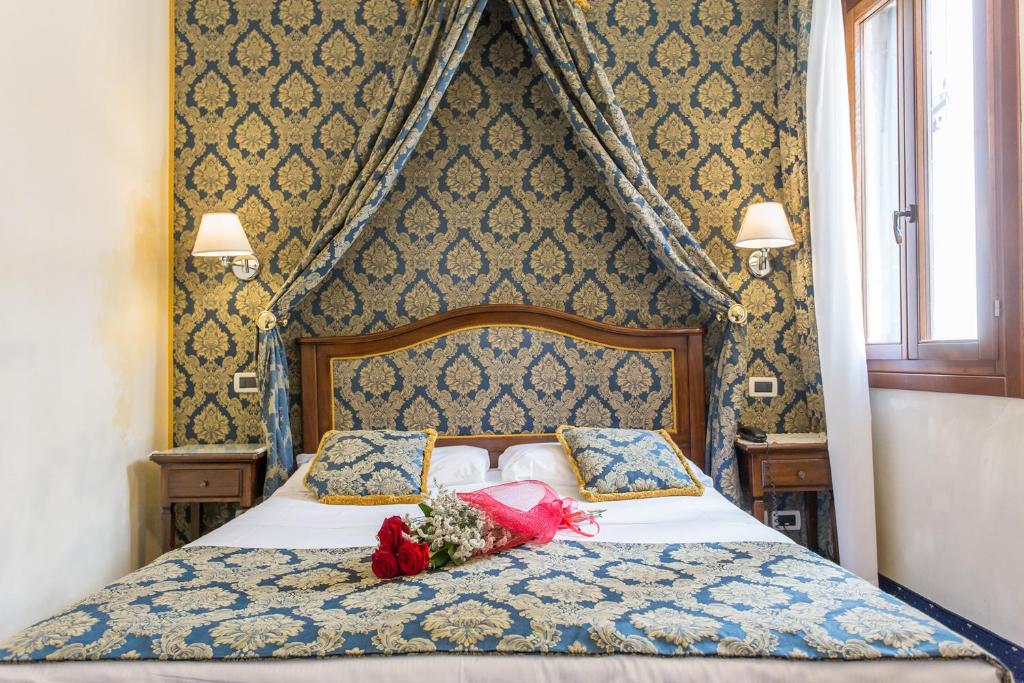 a bedroom with a bed with a flower arrangement on it at Residenza Rivo Alto in Venice